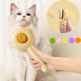Cargar la imagen en la vista de la galería, Brosse poils chat de couleur beige tenue à la main avec un chat à poils longs en arrière-plan