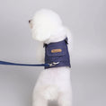Charger l'image dans la visionneuse de la galerie, Chien blanc portant une veste pour chien bleue avec poche et laisse attachée à l'intérieur