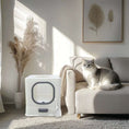 Charger l'image dans la visionneuse de la galerie, Bac à litière design chat Oscar et Plume blanc avec porte ronde et pelle dans un salon moderne