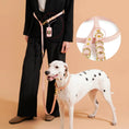 Load image into Gallery viewer, Laisse mains libres pour chien en cuir rose avec harnais ajustable portée par une personne vêtue de noir