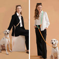Load image into Gallery viewer, Laisse mains libres pour chien Oscar et Plume portée par femme en tenue élégante avec deux Dalmatiens