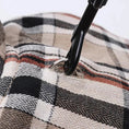 Charger l'image dans la visionneuse de la galerie, Détail du tissu à carreaux beige et noir du manteau réversible pour chien avec attache noire