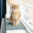 Charger l'image dans la visionneuse de la galerie, Chat assis sur un tapis de fenêtre pour chat gris tricoté d'Oscar et Plume près d'une fenêtre