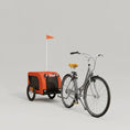 Load image into Gallery viewer, Remorque vélo chien orange attachée à un vélo gris avec selle jaune devant un garage moderne