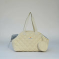 Load image into Gallery viewer, Sac imperméable chien chat beige matelassé avec poches et poignées longues porté à la main
