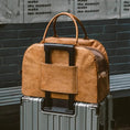Load image into Gallery viewer, Sac voyage design petit chien en cuir camel posé sur une valise grise avec poignée télescopique