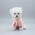 Charger l'image dans la visionneuse de la galerie, Petit chien blanc portant un sweat doux capuche chien rose avec motifs coeurs rouges à l'intérieur