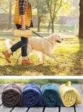 Load image into Gallery viewer, Tapis imperméable pour chien plié en différentes couleurs transporté lors d'une promenade en extérieur