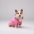 Carica l'immagine nel visualizzatore della galleria, Chien portant un vêtement de pluie pour chien rose Oscar et Plume assis près d'un mur en briques blanches