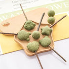 Boule comestible pour chat en différentes formes sur bâtonnet en bois avec texture verte