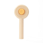 Brosse poils chat beige avec poignée ergonomique pour un toilettage facile et efficace