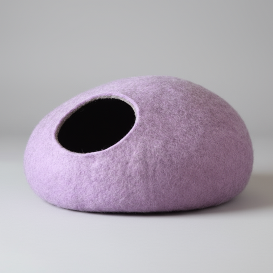 Cocon laine mérinos pour chat de couleur lavande posé sur un sol en bois clair