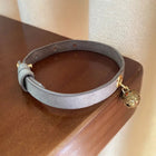 Collier à clochette pour chat Oscar et Plume en simili cuir gris avec une clochette dorée