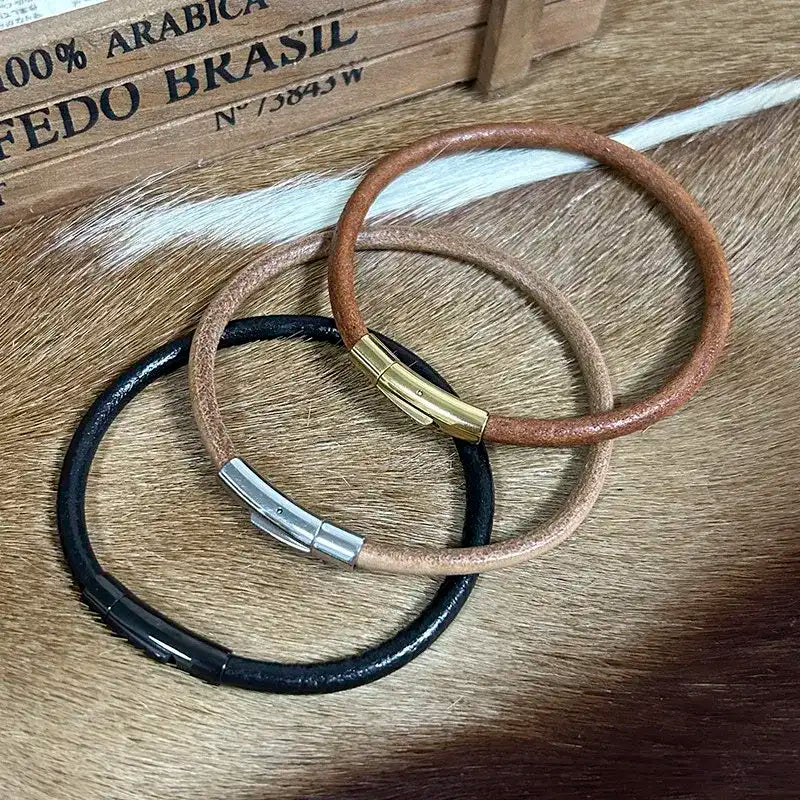 Trois colliers en cuir pour chat en noir, brun et clair, de la marque Oscar et Plume