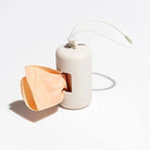 Distributeur de sacs pour chien beige avec ouverture pour sortir les sacs et accroche cordon