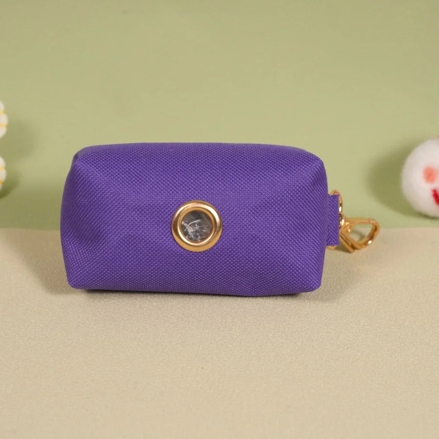 Distributeur sacs pour chien en violet avec accroche en or et design élégant.