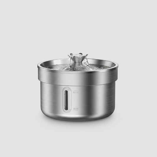 Chat buvant à une fontaine pour chat inox en acier brossé Oscar et Plume sur sol en bois