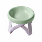 Gamelle sur pieds pour petit chien de couleur verte avec support en plastique rose.