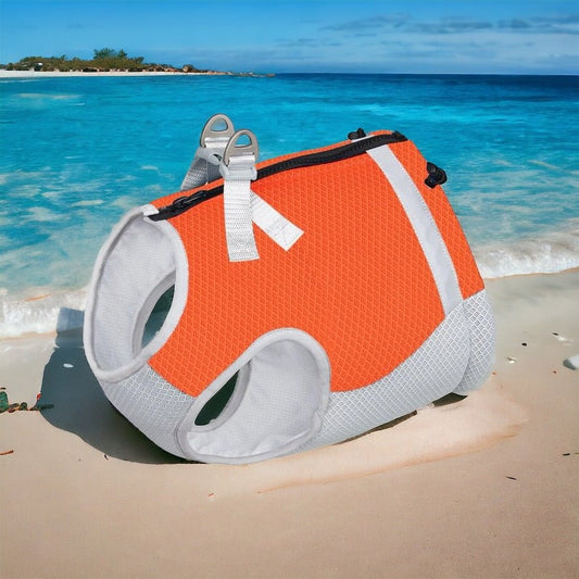 Gilet rafraîchissant pour chien orange et gris de Oscar et Plume posé sur une plage au bord de l'eau