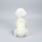 Chien blanc portant un t-shirt élégant pour chien à motifs de cœurs roses sur fond vert pâle