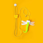 Jouet pour chat dragonfly vert fluo avec ailes translucides et clochette sur fond jaune
