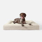 Lit design pour chien Oscar et Plume en tissu beige doux avec un chien allongé dessus