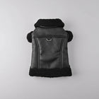 Manteau pour petit chien noir en tissu effet cuir avec col en fourrure douce tenu à la main