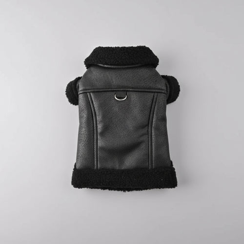 Manteau pour petit chien noir en tissu effet cuir avec col en fourrure douce tenu à la main