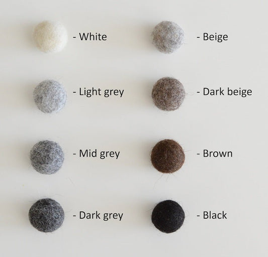 Palette de couleurs naturelles pour cocon en laine tyrolienne, incluant blanc, gris clair, gris moyen, gris foncé, beige, beige foncé, brun, et noir.