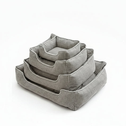 Panier chien déhoussable Oscar et Plume en tissu rayé gris et blanc empilés sur parquet