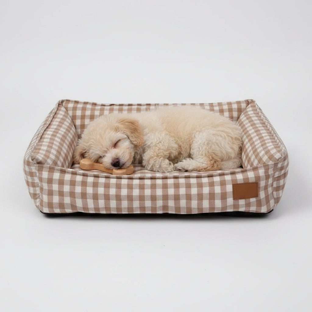 Chien dormant paisiblement dans un panier déhoussable pour chien à motif vichy beige