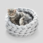 Chat gris allongé dans un panier design pour chat gris tressé en tissu moelleux