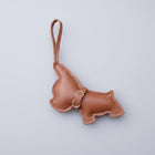 Porte clés bouledogue en cuir marron avec un design amusant tenant dans une main