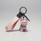 Porte-clés bouledogue rose avec bracelet en cuir rose et rivets dorés tenu à la main