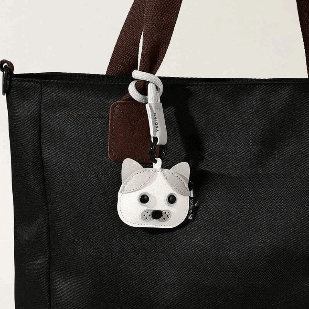 Porte-clés chien mignon en forme de tête de chien accroché à un sac noir