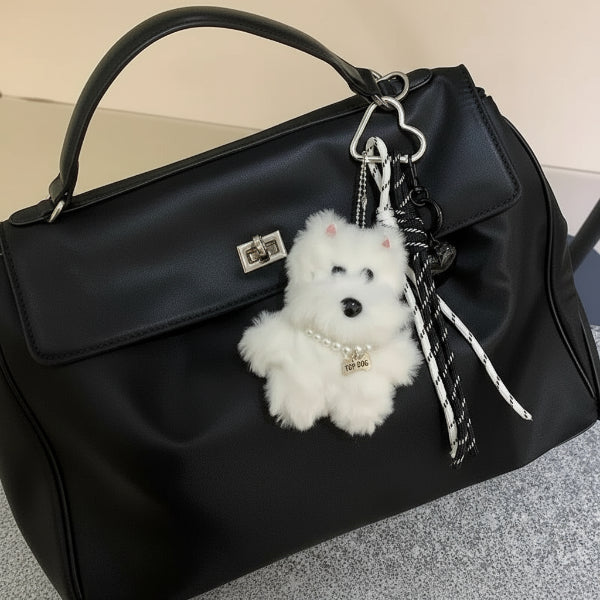 porte-clés chien peluche blanc accroché à un sac noir avec mousqueton en forme de coeur Oscar et Plume