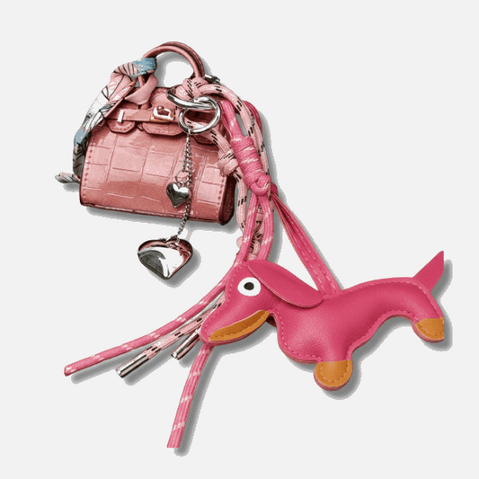 Porte-clés teckel en cuir rose attaché à un sac à main élégant avec détails colorés