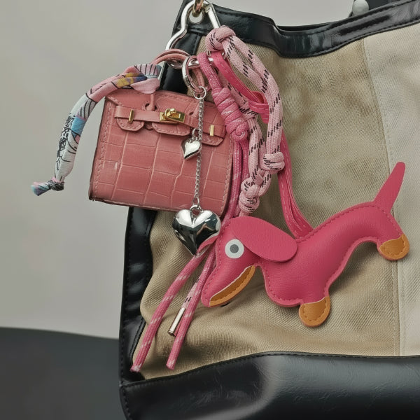 Porte-clés teckel en cuir rose avec accessoires sur un sac à main élégant