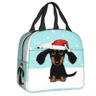 Sac isotherme teckel avec un dessin de teckel portant un chapeau de Noël sur fond bleu