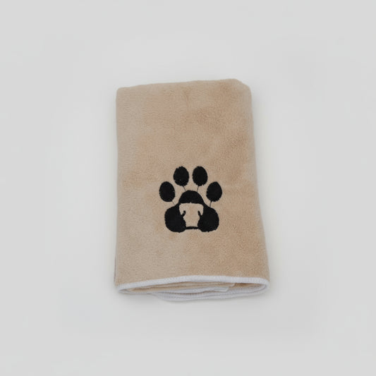 Serviette pour chien et chat beige avec motif patte noire pliée