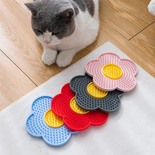 Tapis à lécher pour chien et chat en forme de fleurs colorées avec un chat gris et blanc à côté