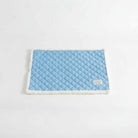 Tapis réversible pour chat et chien bleu avec bordure blanche moelleuse sur canapé blanc