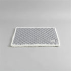 Tapis réversible pour chat et chien gris avec bord en fausse fourrure sur canapé blanc