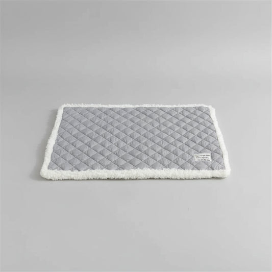 Tapis réversible pour chat et chien gris avec bord en fausse fourrure sur canapé blanc