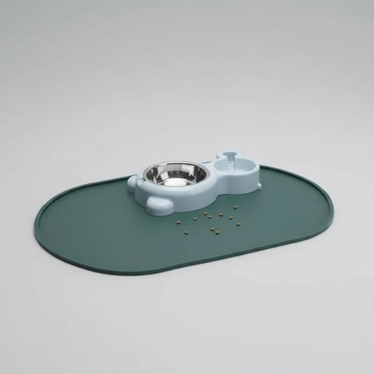 Chat gris mangeant sur un tapis silicone gamelle vert avec bol et distributeur d'eau